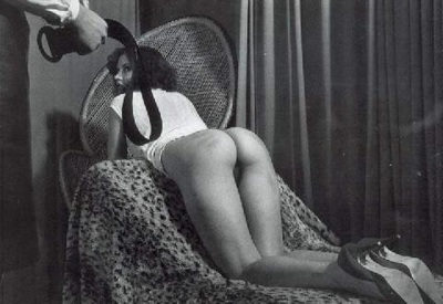 slave guarda master in una scena di spanking, bianco e nero