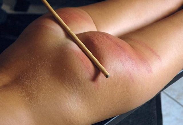 Schiava sdraiata prona, percossa con la canna: segni rossi visibili sulle natiche.